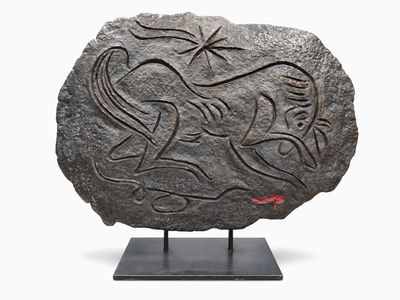 une image représentant une pierre ornée d'un motif, posée sur un socle