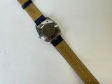 a close up of a watch on a white surface with a black strap