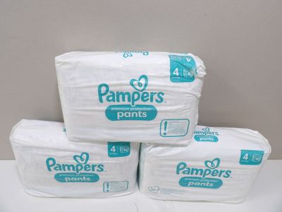 three packs of pampers pants sitting on top of each other