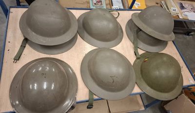 six helmets sitting on a table in a room