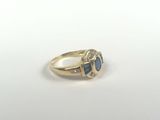 a close up of a gold ring with a blue stone