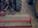 a tractor that is sitting in the dirt with a plow