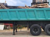 a green dump truck parked in front of a building