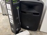 une enceinte posée par terre à côté d'une boîte