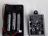 two batteries are sitting in a battery holder on a white surface
