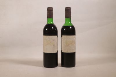 deux bouteilles de vin posées l'une à côté de l'autre sur une surface blanche