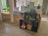 une pièce avec un bureau, des étagères et des jouets