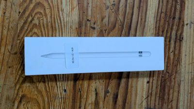 an apple pencil in a white box on a wooden surface