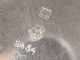 a close up of a silver plate with a stamp on it
