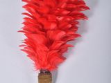 un gros plan d'un pinceau en plumes rouges sur une surface blanche