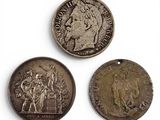 trois pièces de monnaie anciennes sont exposées sur un fond blanc