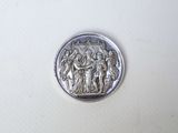 an image of a silver coin with an image of a man and a woman on it