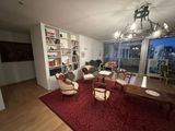 a living room with a red carpet and a large window