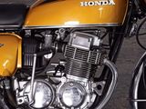 a yellow motorcycle that is parked in a parking lot