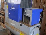 un compresseur d'air bleu et blanc posé dans un garage