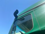 a green truck that is parked on the side of the road