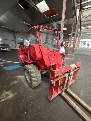 a red tractor that is parked in a garage