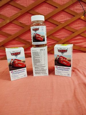 trois boîtes de dentifrice « Cars » posées sur un lit