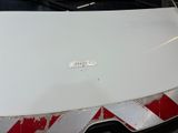 a close up of a white car with a red and white stripe on it