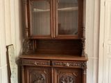 a wooden china cabinet in the corner of a room