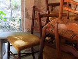 several chairs and a table in a room with a stone wall