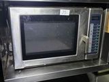 a microwave that is sitting on a shelf in a kitchen