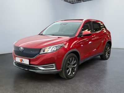 Le SUV rouge est garé dans une pièce au sol noir.