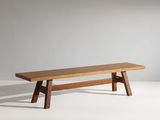 un banc en bois posé sur un sol blanc, près d'un mur
