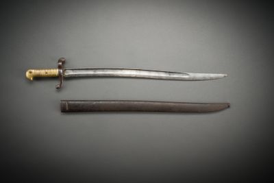 an image of a knife and a sword on a gray surface