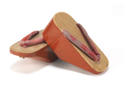 PAIRE DE GETA en bois laqué rouge.