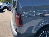 a silver van parked in a parking lot with other cars in the background