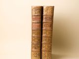 deux vieux livres posés l'un sur l'autre sur une table