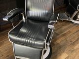 un fauteuil de coiffeur noir placé devant un miroir
