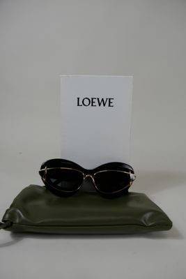 quelqu'un tient une carte et une paire de lunettes de soleil posées sur un oreiller