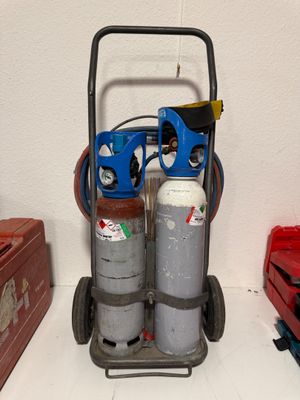 un chariot sur lequel sont posés deux bouteilles, à côté d'une boîte à outils