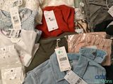 a pile of clothing that is sitting on a bed
