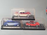 three toy cars in a display case on a table