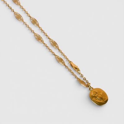 un collier en or avec une pièce de monnaie sur une chaîne