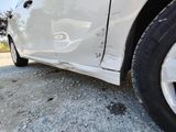 a white car that has been badly damaged and is parked on the side of the road