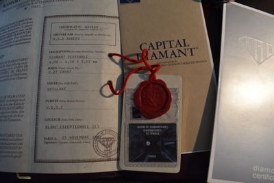 un cachet de cire rouge posé sur un livre, à côté d'une paire de ciseaux