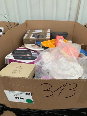une boîte en carton remplie d'objets divers, posée par terre