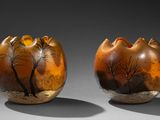 deux vases marron ornés d'arbres, posés sur une table