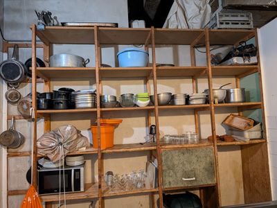 many pots and pans on the shelves in the kitchen