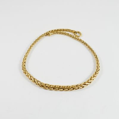 un bracelet en or avec un motif de tresse sur fond blanc
