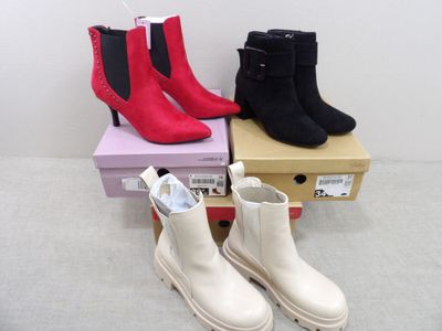 trois paires de bottes sont empilées les unes sur les autres