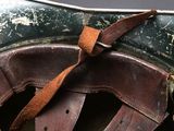 a close up of a brown leather saddle with a leather strap