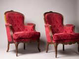 paire de fauteuils rembourrés rouges avec des pieds en bois sculpté