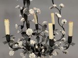 un lustre auquel sont suspendues des bougies et des fleurs
