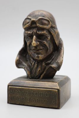 buste en bronze représentant un homme portant une casquette de pilote et des lunettes de protection