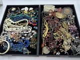 deux plateaux de bijoux posés sur une table